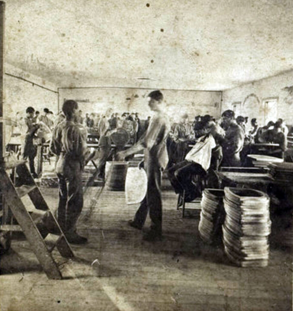 Historic photo of boys making chairs in reform school workroom.