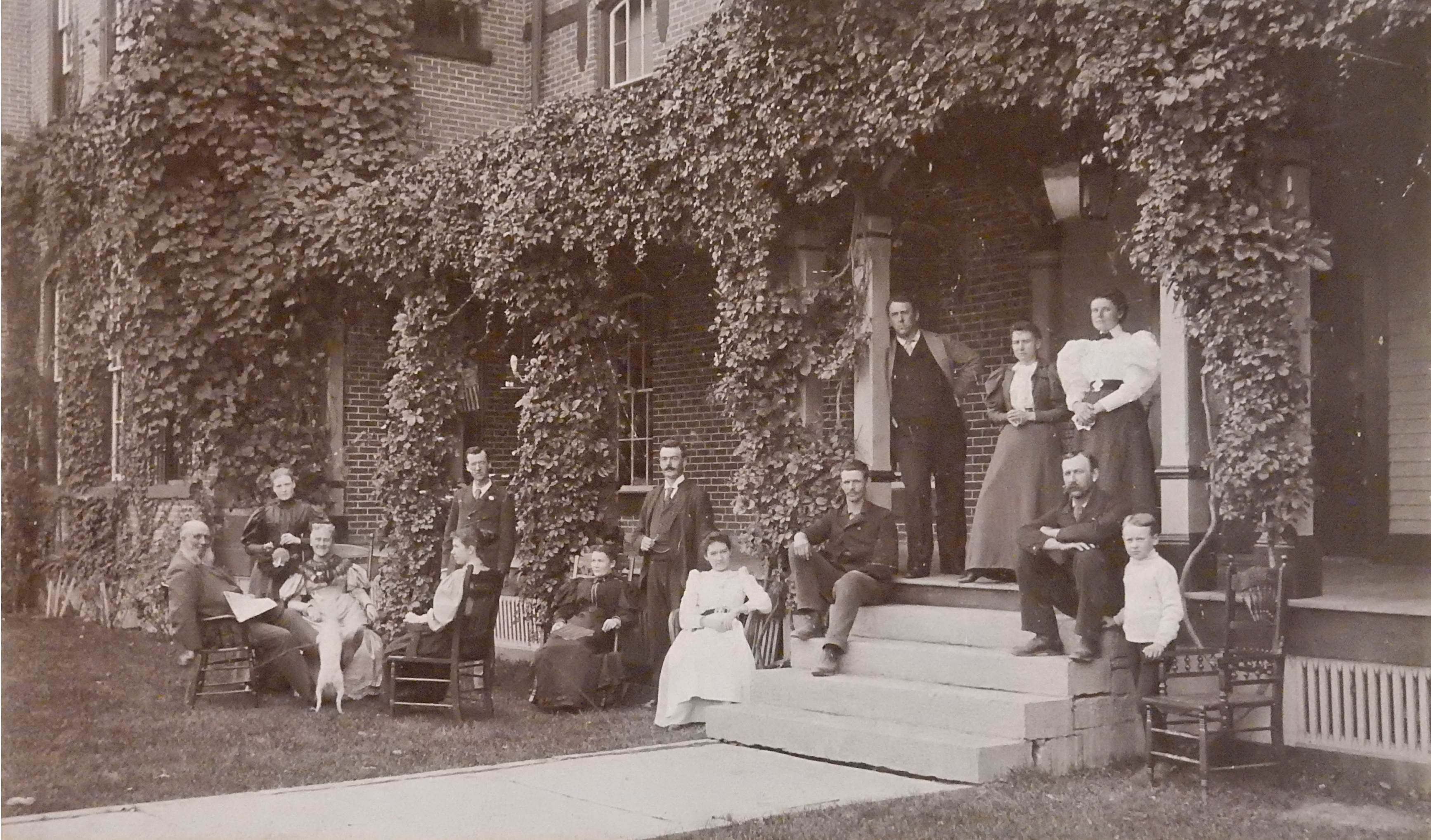 Photograph of institution staff sitting outside main building, 1893.